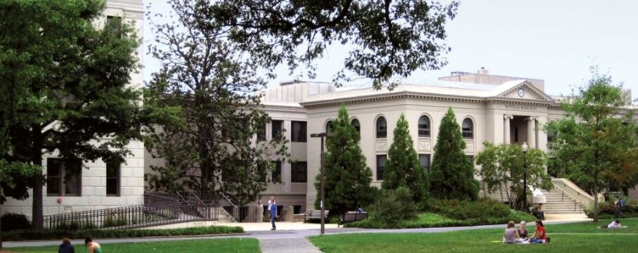 College campus scene with students on the lawn and classic architecture.