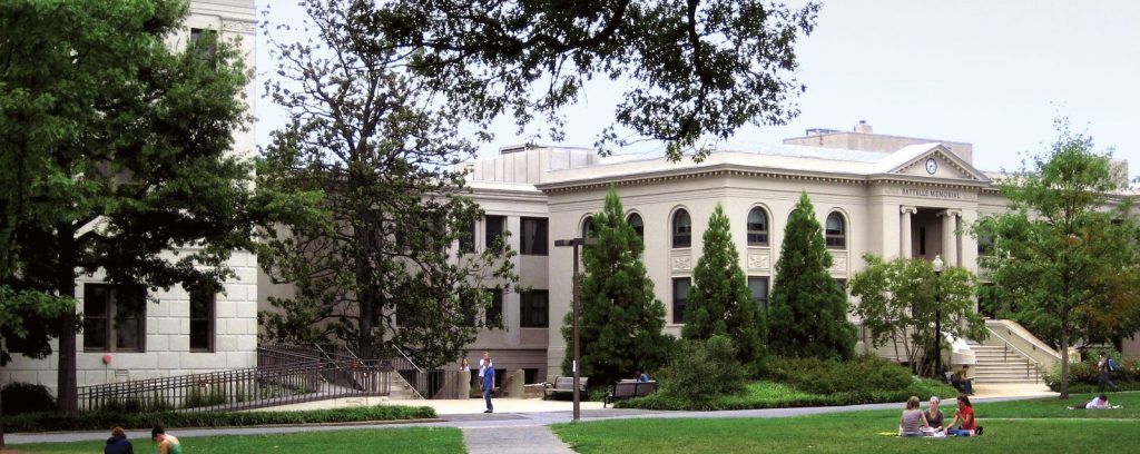 College campus scene with students on the lawn and classic architecture.
