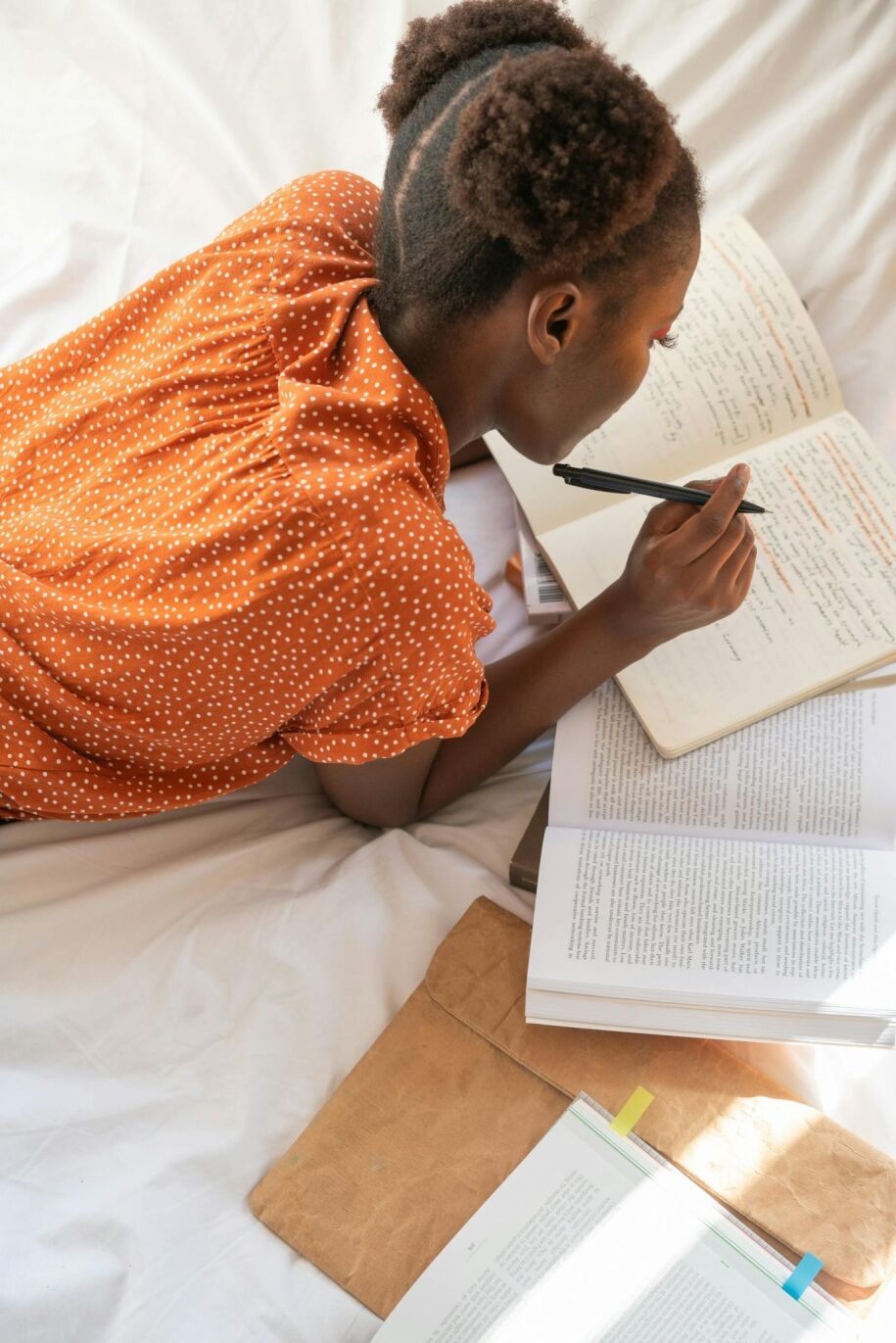 Student studies with books and notes, preparing for college applications.