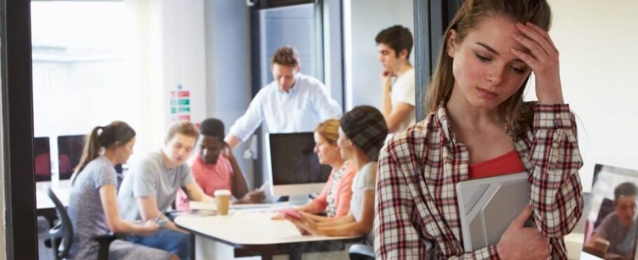 Stressed student with head in hand, study group in background.