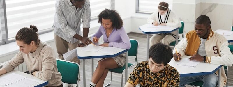 teacher helping a student in a classroom