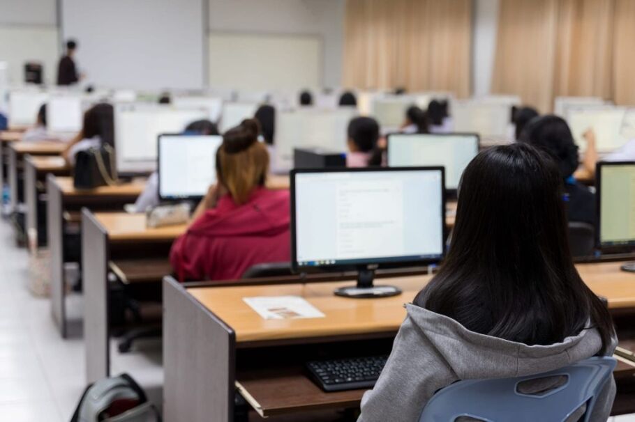 Students working on computers in a classroom, focused on academic success.