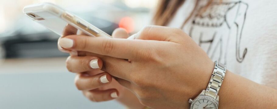 Student using phone to connect with college admissions counseling services.