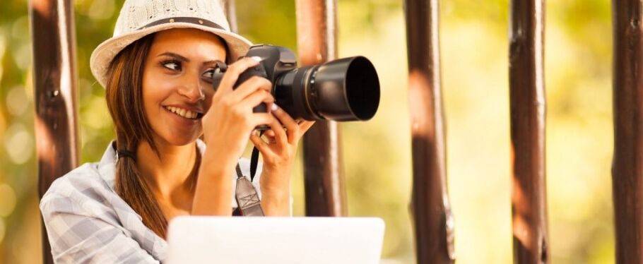 Smiling student with camera and laptop explores visual storytelling for college application.