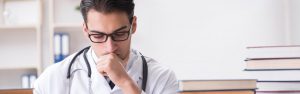 Medical student considers college and career options with books nearby.
