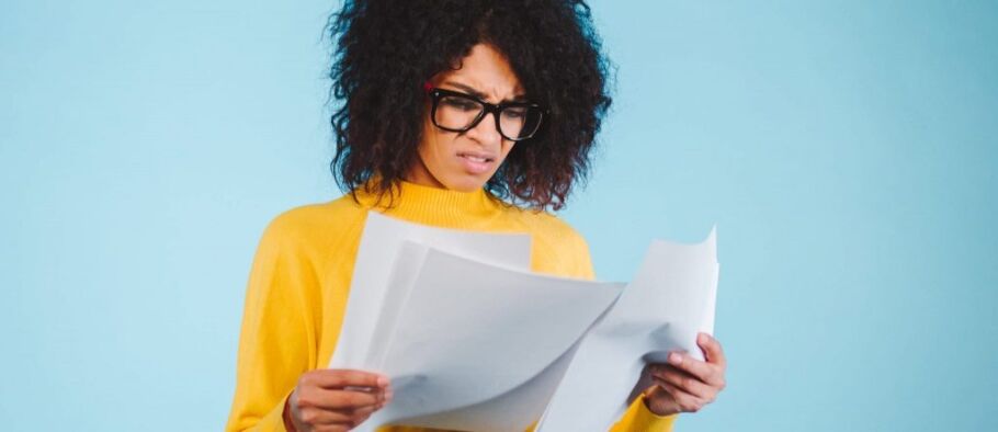 Student looking confused while reviewing college application documents.
