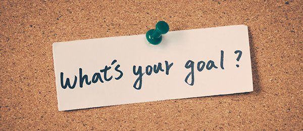 Note on corkboard asks: What's your goal? Green pushpin.