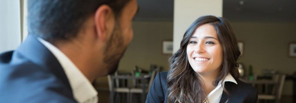 Smiling student meets with college counselor for admissions advice.