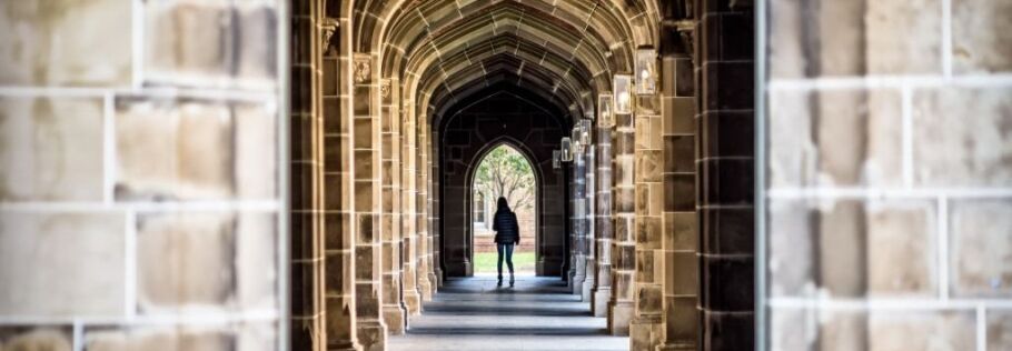 Student walking through a stone archway, symbolizing the path to college.