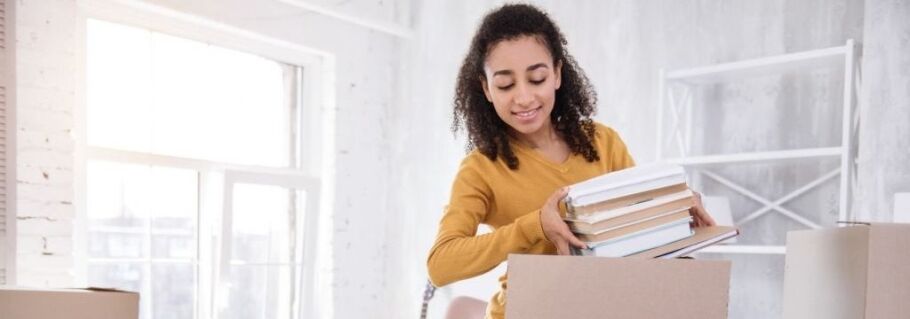 Student packing books, preparing for college with IvyWise guidance.
