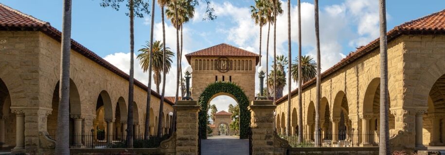 Campus architecture with arches and palm trees, symbolizing higher education goals.