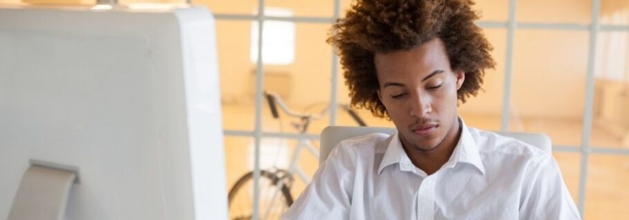 Student concentrating on college application essay at computer.