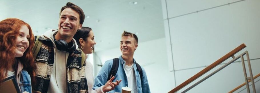 Smiling students walking on stairs, representing college life and academic success.