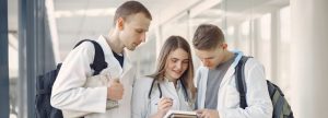 Pre-med students collaborate on notes in a bright, modern hallway.