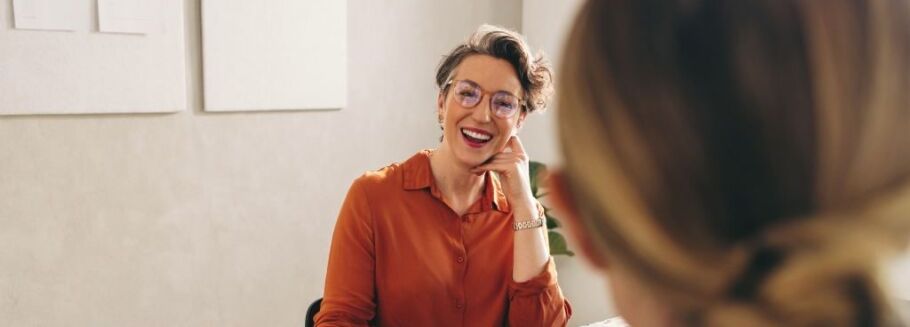 Smiling college counselor meets with student to discuss academic goals.