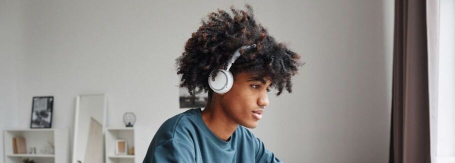 Student wearing headphones studies for college admissions test.