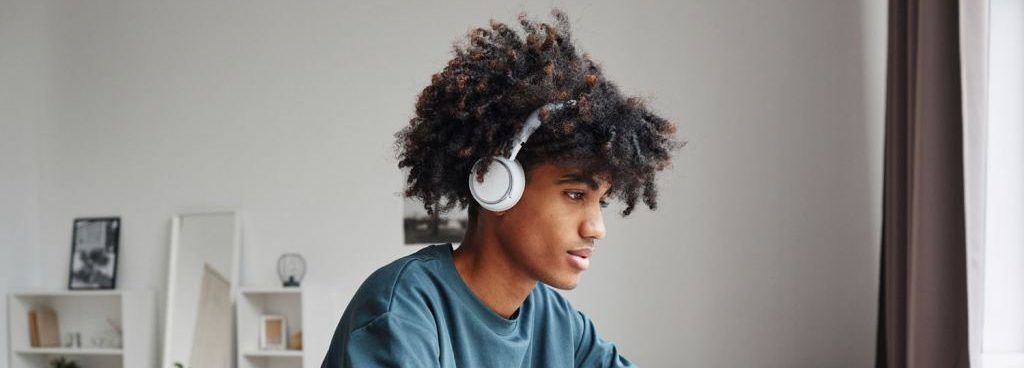 Student wearing headphones studies for college admissions test.