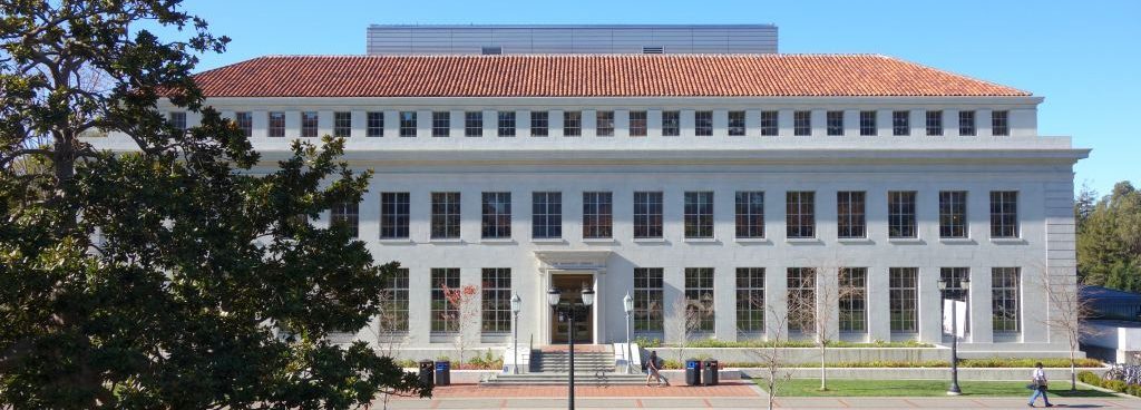 College campus building with red tile roof and many windows.