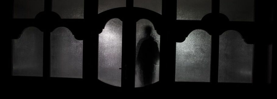 Silhouette of a person behind frosted glass, representing college application anxiety.