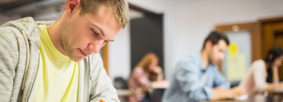 Students concentrating while studying or taking a test in a classroom.