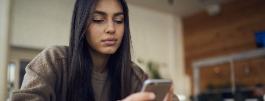 Student using phone to research college admissions information online.