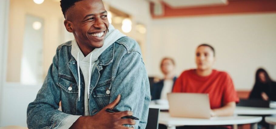 Smiling student in class, engaged in learning and college preparation.
