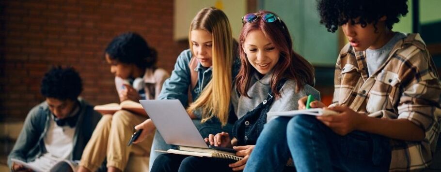 College students studying and collaborating with laptops and notebooks