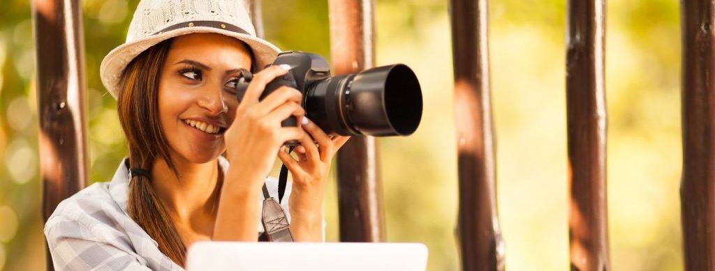 Smiling student with camera and laptop explores visual storytelling for college application.