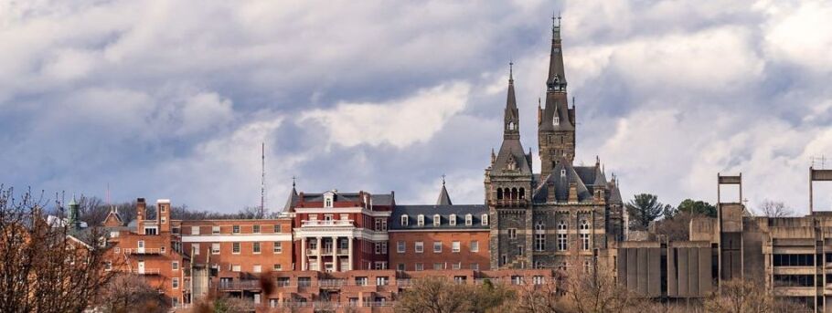 Campus buildings with gothic spires under a cloudy sky.