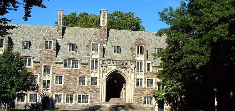 Ivy League college campus building with stone facade and arched entrance.