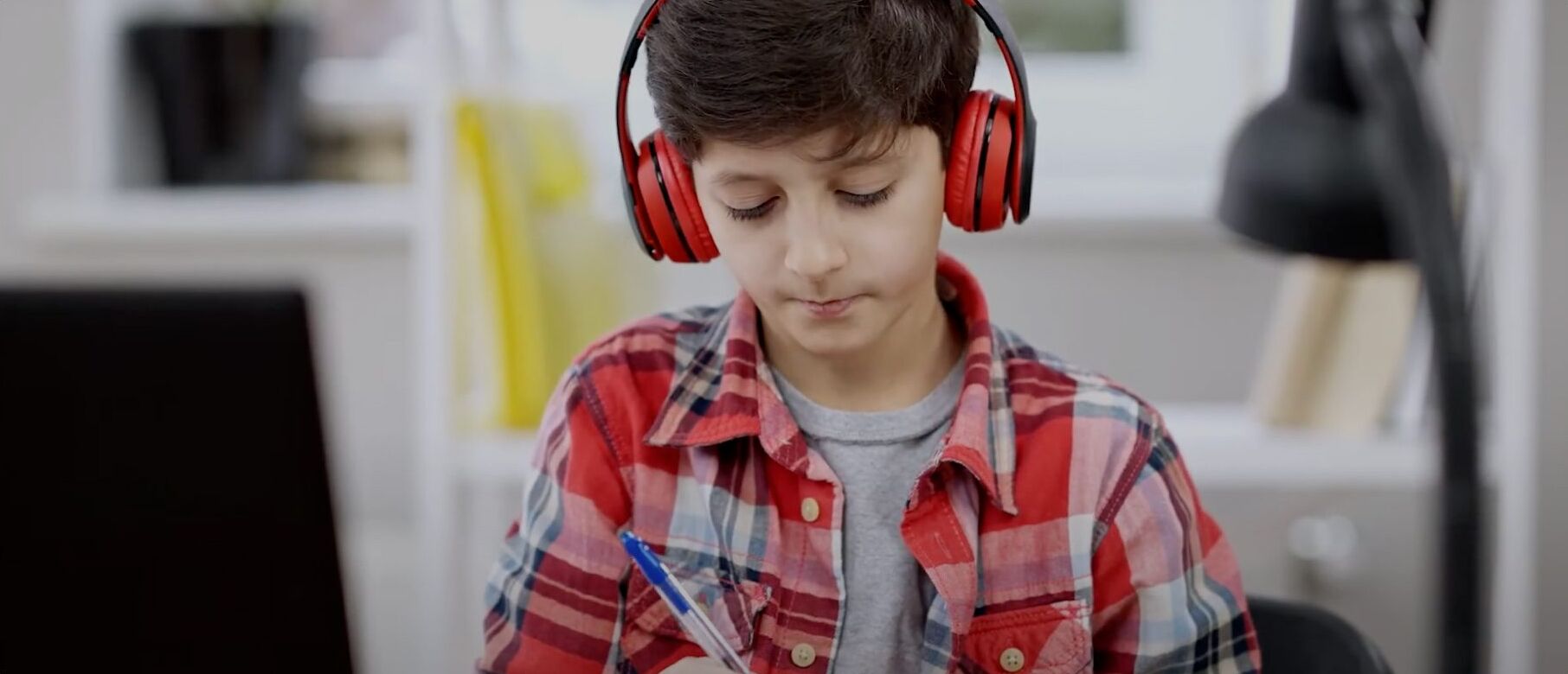 Student with headphones studies, focused on academic success and college preparation.