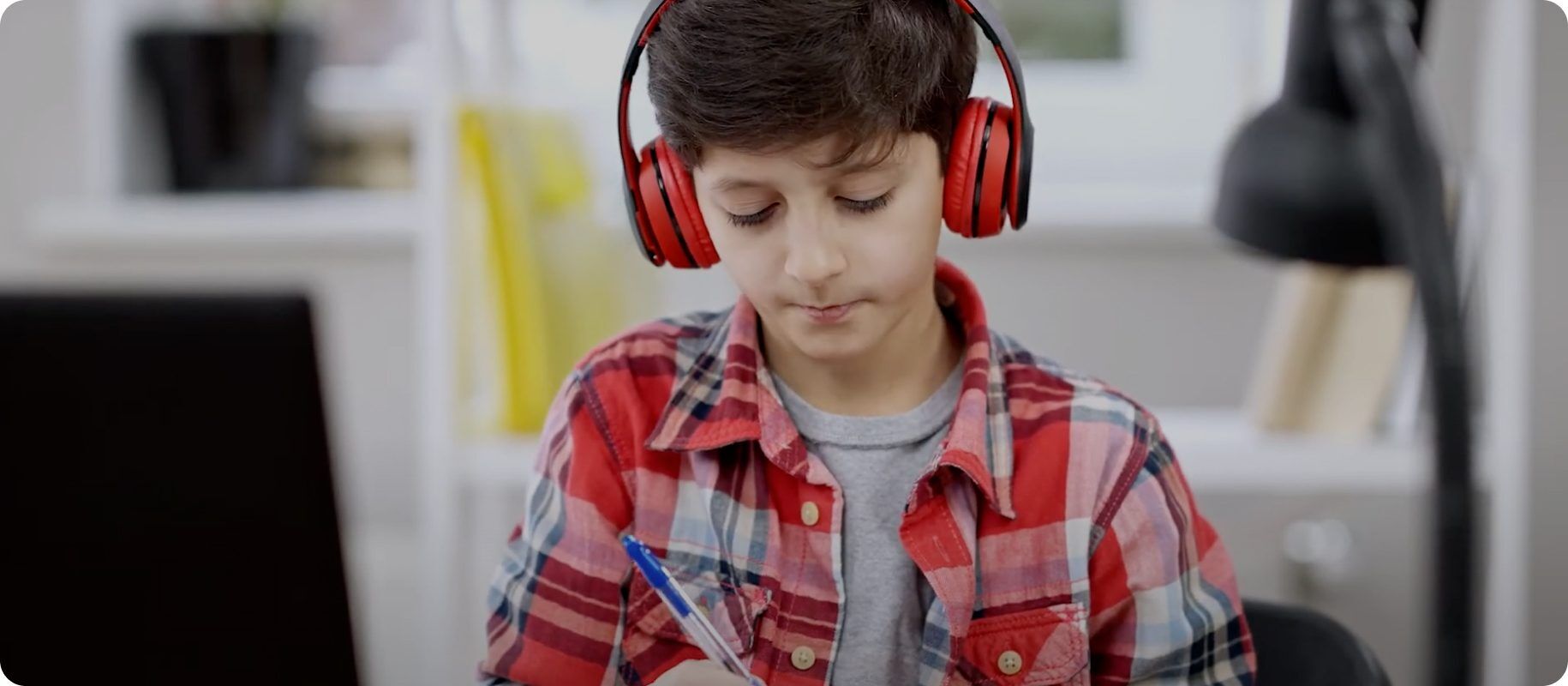 Student with headphones studies, focused on academic success and college preparation.