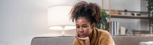 Pensive student considers college application process and future academic goals.