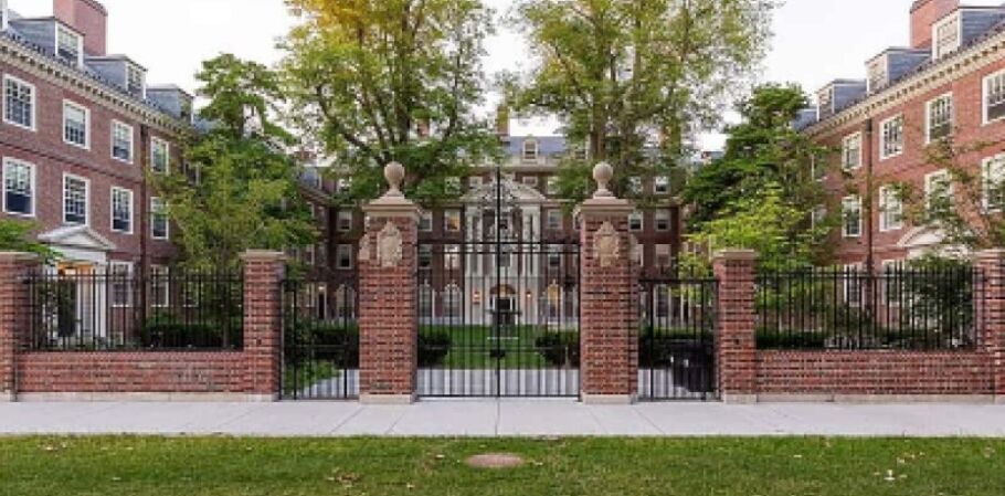 Ivy League campus with brick buildings, green trees, and wrought iron fence.
