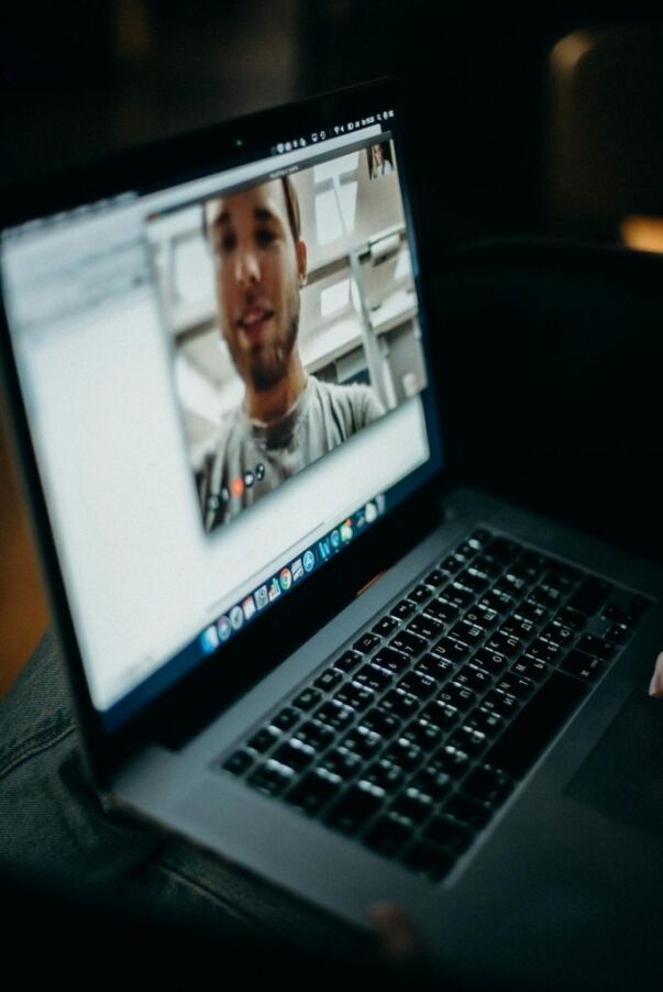Laptop screen showing a student on a video call with an advisor.