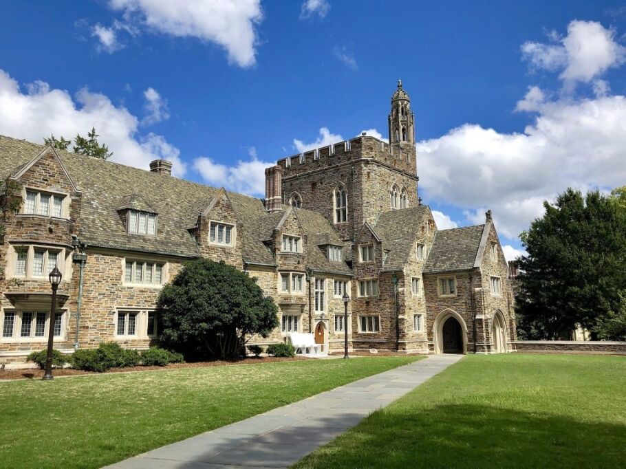 Collegiate gothic architecture on a university campus under a blue sky.