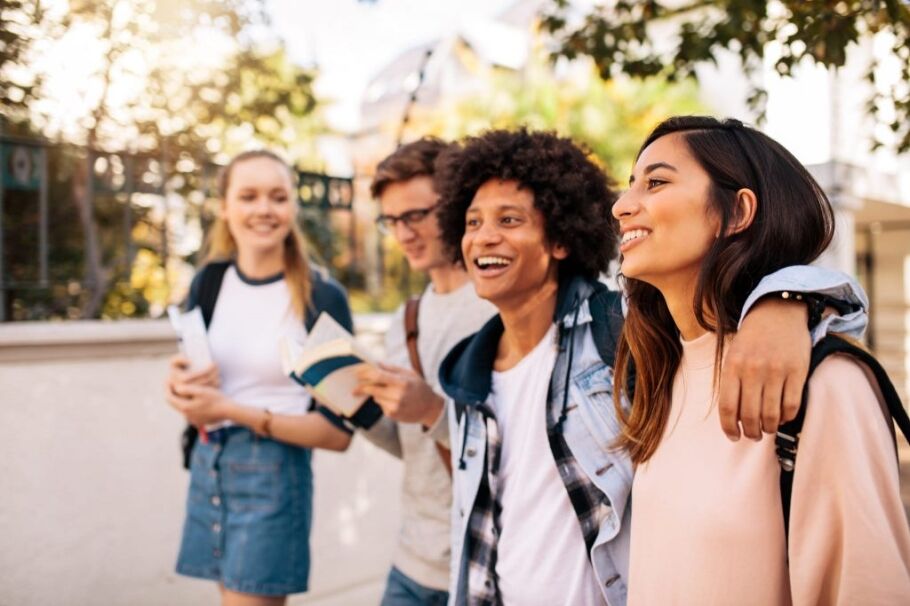 Smiling students walking on campus, excited about college and their academic future.