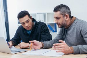 Student works with counselor on college application essay.