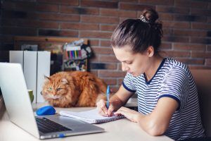 Girl student working with laptop on college essay