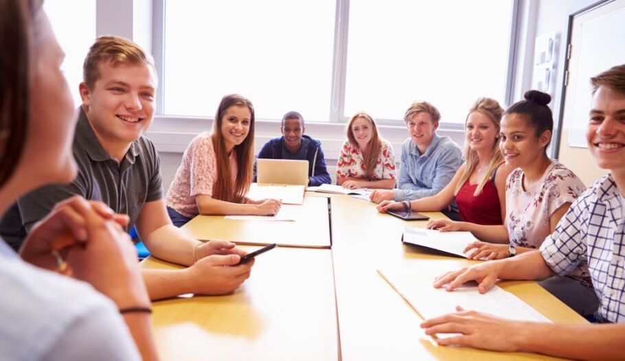 Group Of Students Sitting At Table Having Discussion