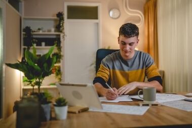 student sitting at desk writing